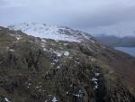 Snowy top of Middlefell beyond the crags.