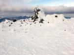 The wind drops briefly.Visibility restored. Summit cairn Raise.