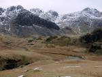 The dark rock of Cam Spout crag rising left to Long Green. Scafell and Scafell Pike to the right.